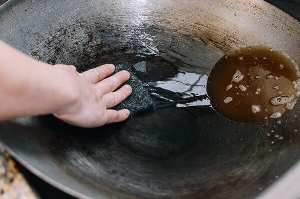 scrubbing wok with scouring pad