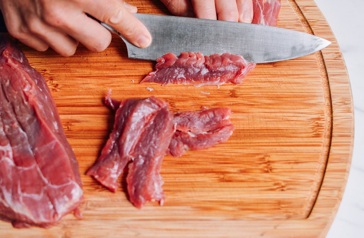 slicing beef flank steak on a cutting board by cwww5.fioekdjsdas.cf