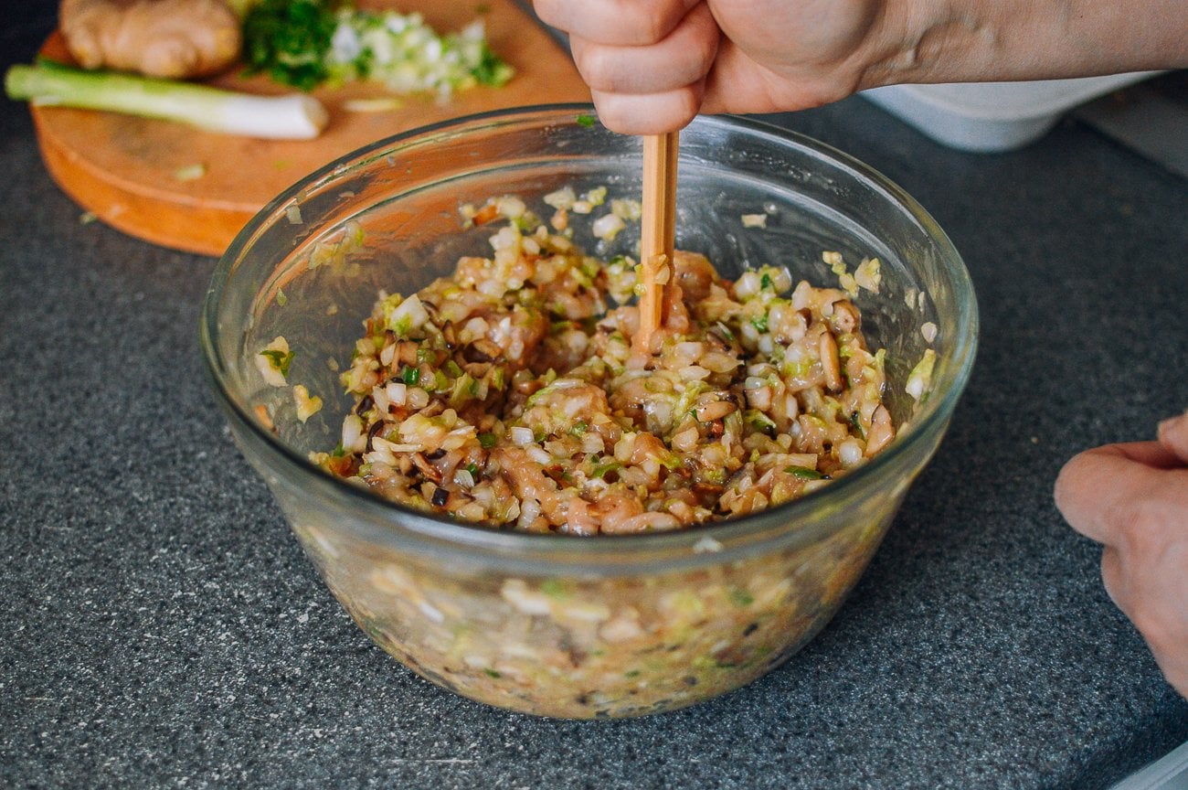 mixing chicken wonton filling with chopsticks