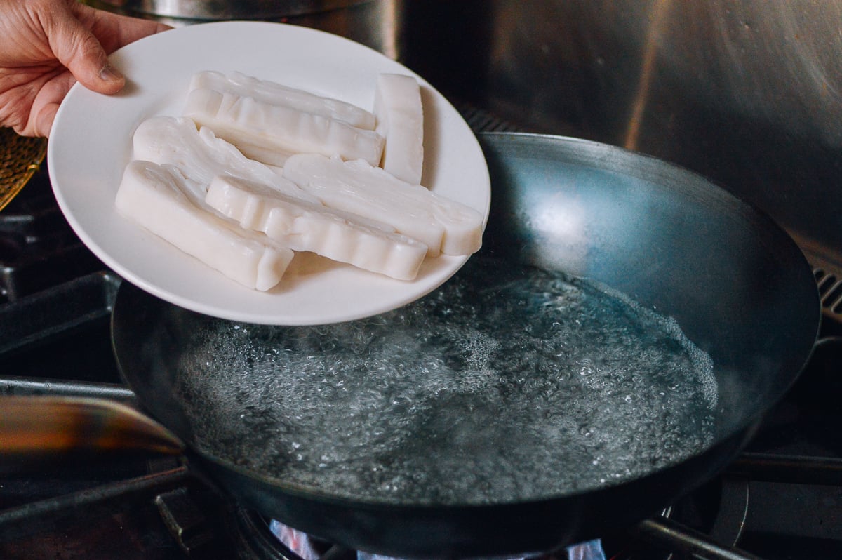 Putting rice noodles in wok filled with boiling water, cwww5.fioekdjsdas.cf