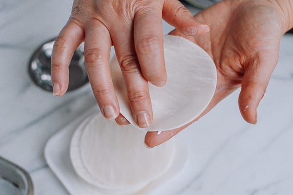 Using a finger to moisten outer edges of dumpling wrapper, cwww5.fioekdjsdas.cf
