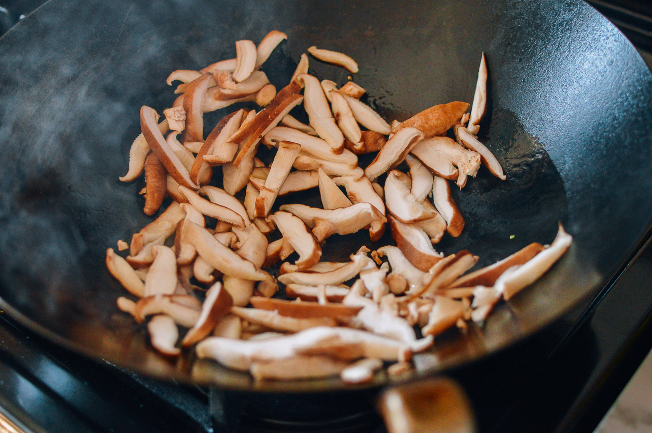 sliced shiitake mushrooms in wok