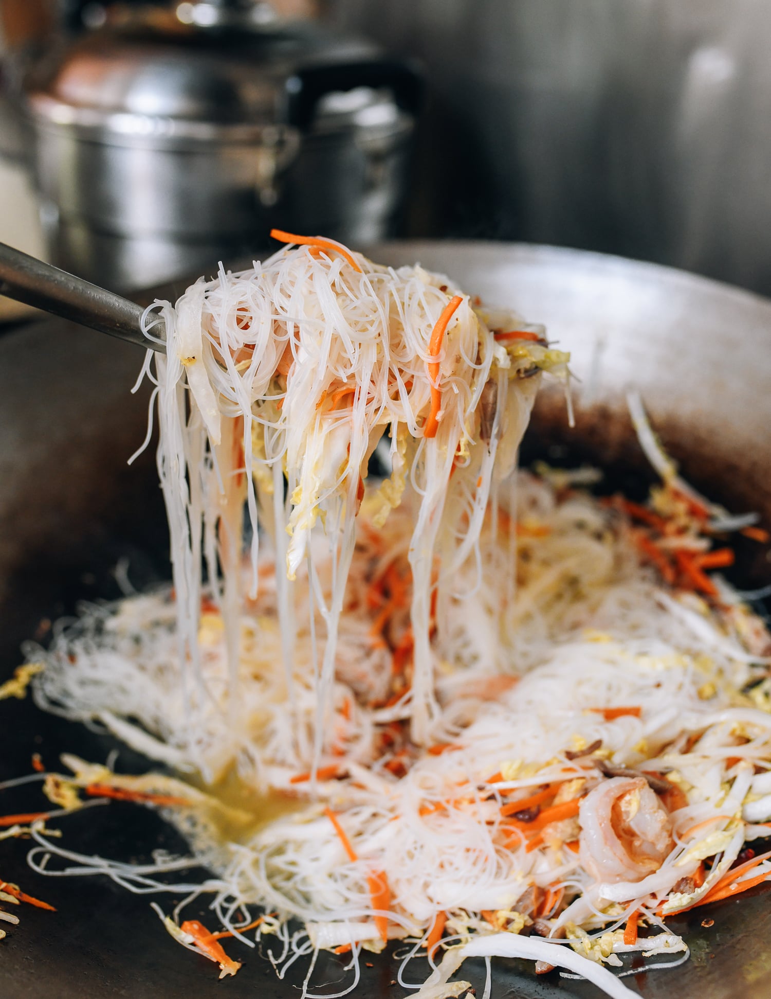 Lifting rice noodles with wok spatula to loosen them, cwww5.fioekdjsdas.cf