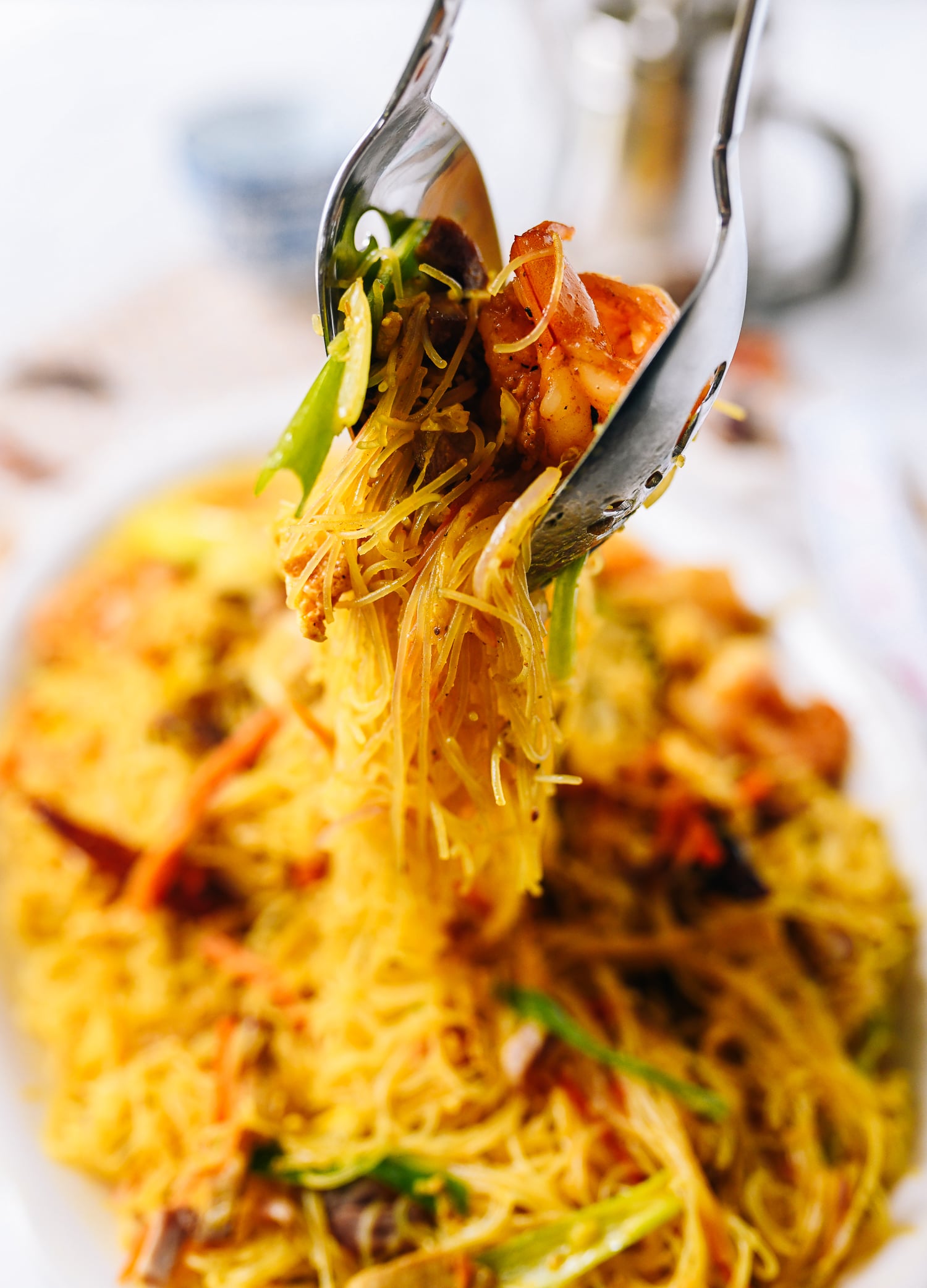 Lifting Singapore noodles off plate with two spoons, cwww5.fioekdjsdas.cf