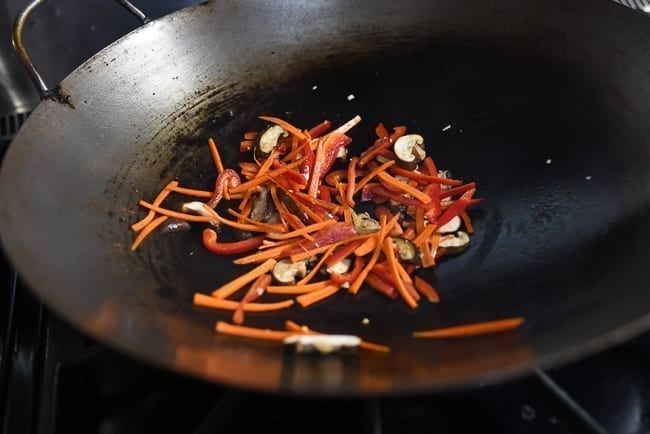 Adding carrots, peppers, and mushrooms to garlic in wok, cwww5.fioekdjsdas.cf