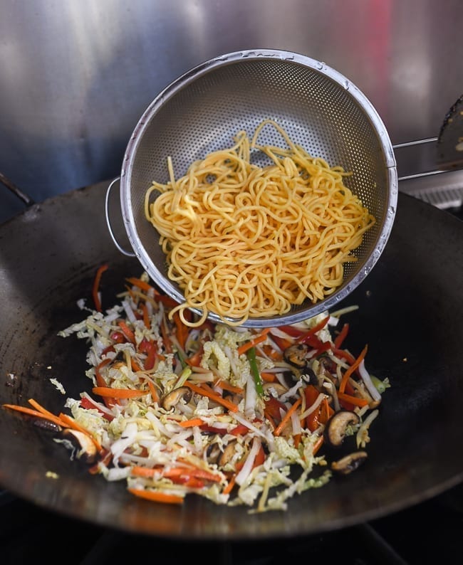 Adding lo mein noodles to vegetables in wok, cwww5.fioekdjsdas.cf