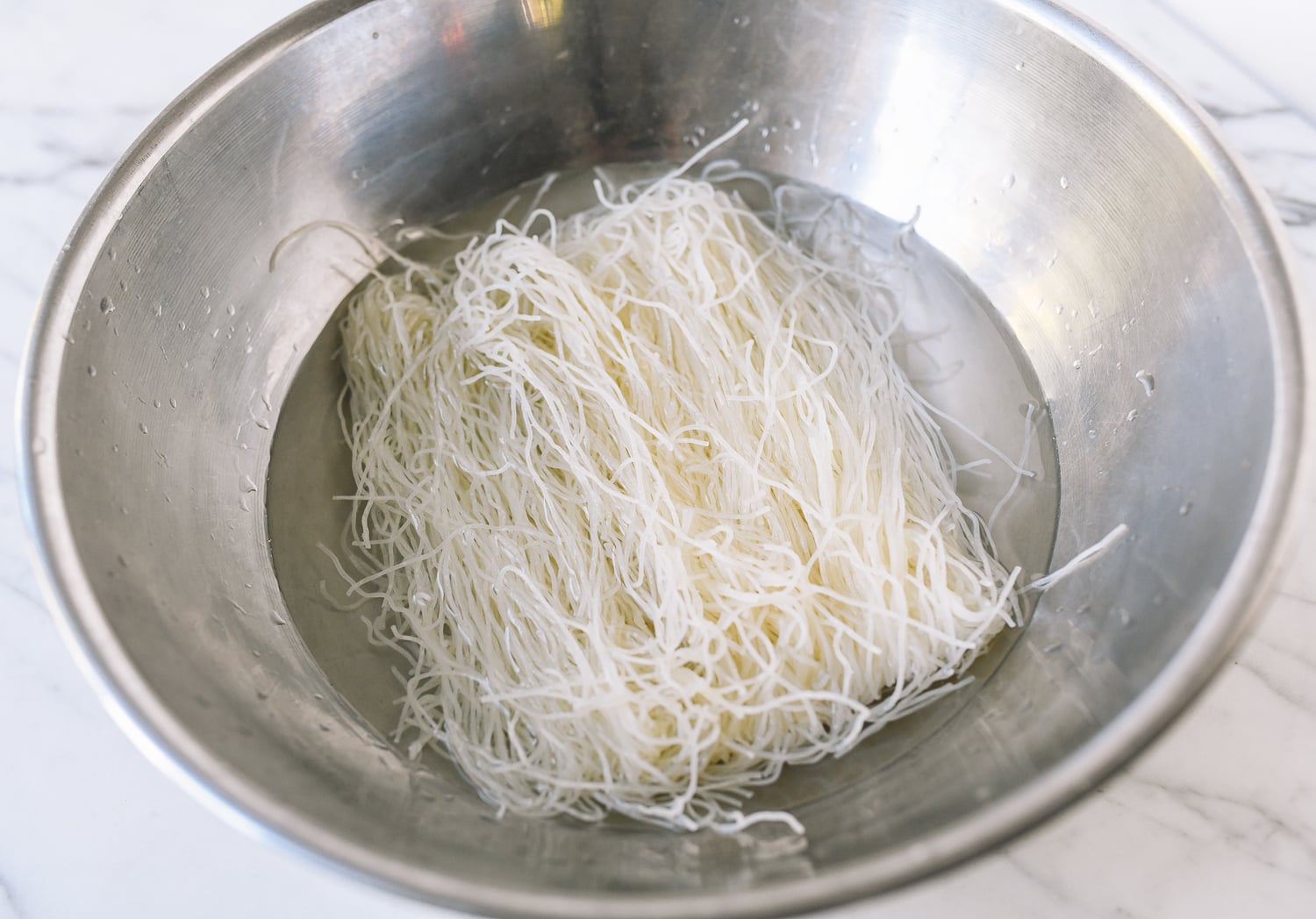Soaking rice noodles in water in metal bowl, cwww5.fioekdjsdas.cf