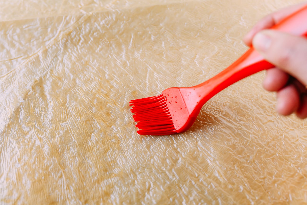 Brushing bean curd skin with oyster sauce and water mixture