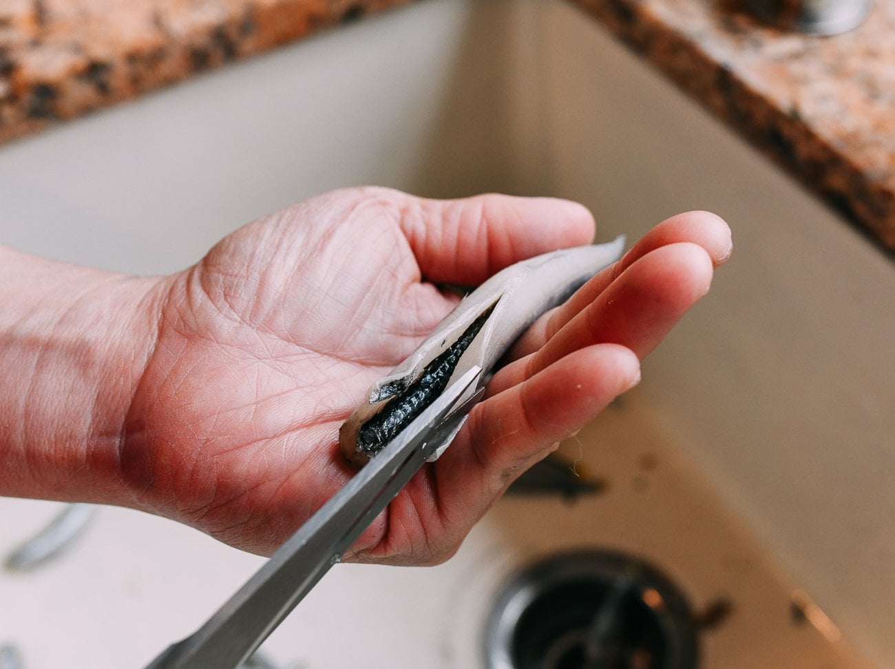 slicing open belly of smelt