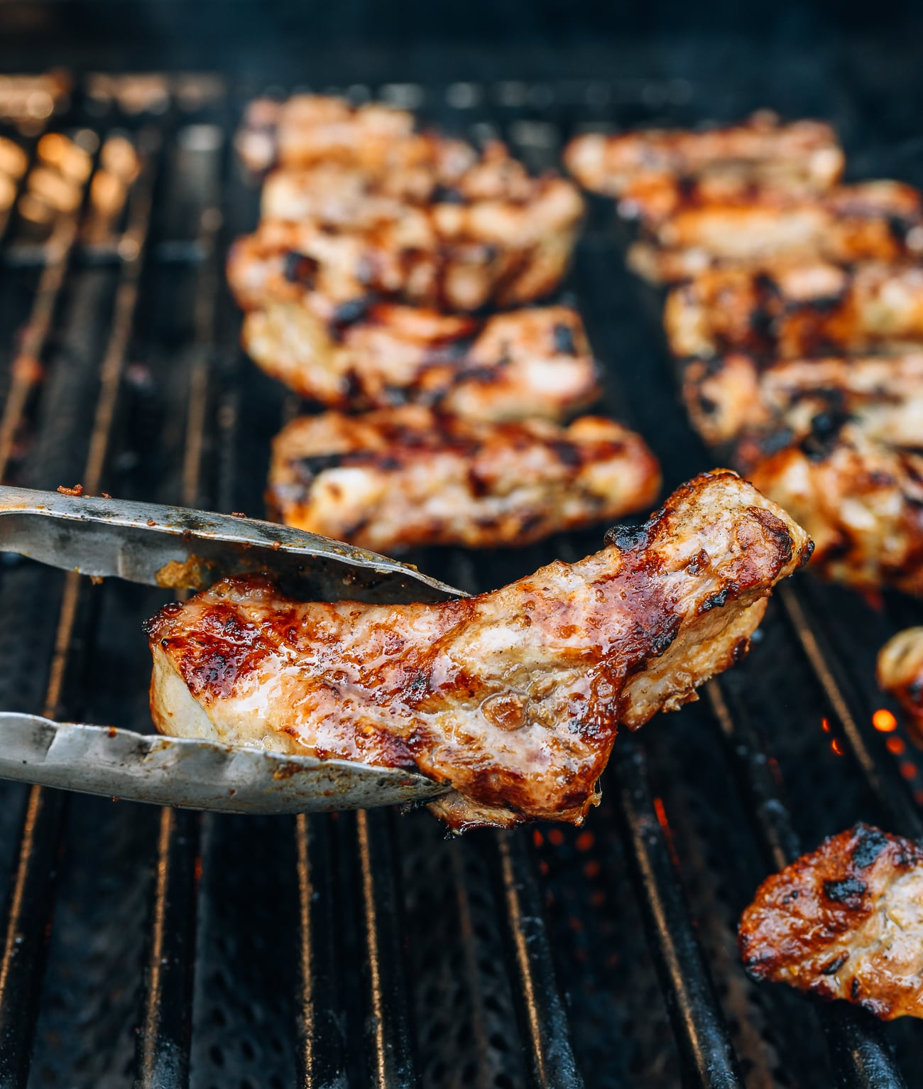 grilling individual ribs with metal tongs