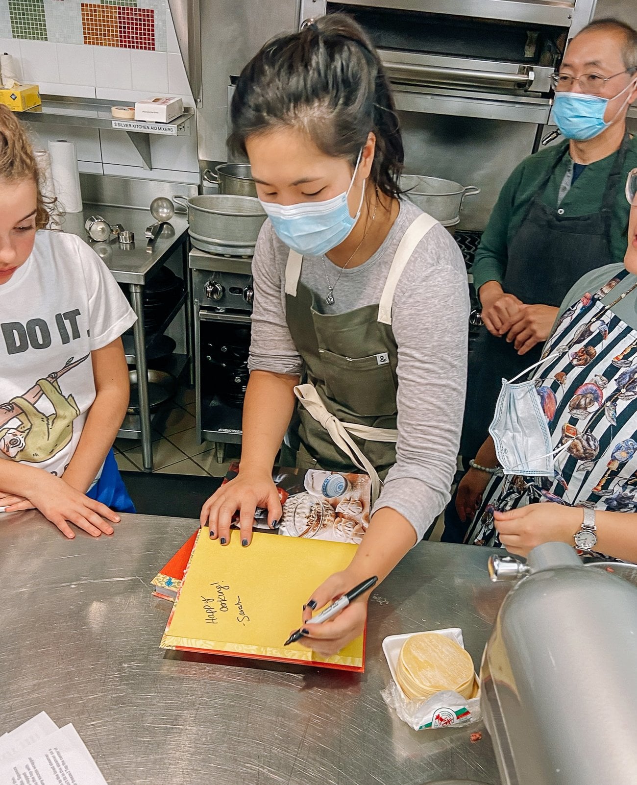 Sarah signing a copy of The Woks of Life cookbook