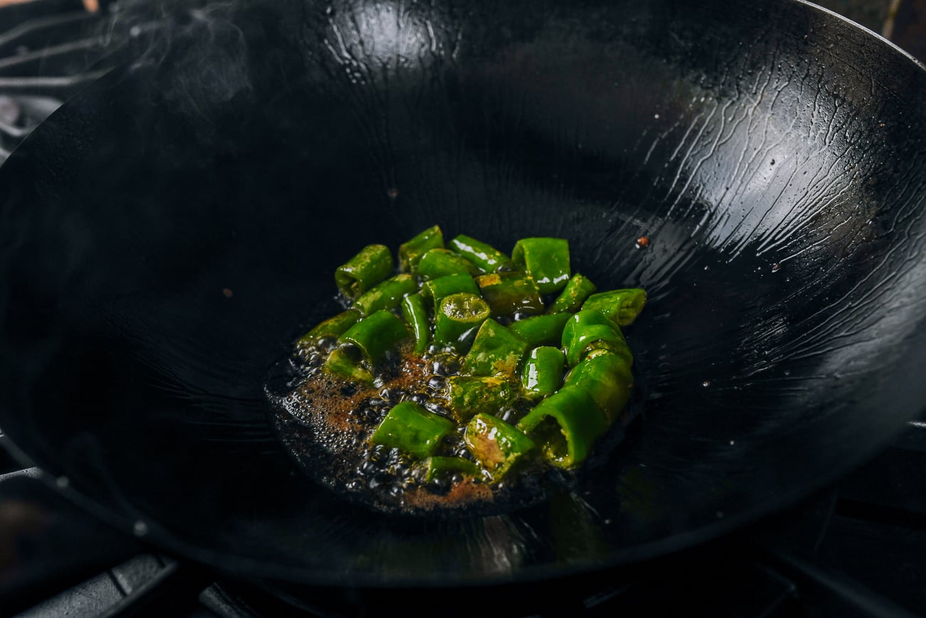 blistering long hot green peppers in oil