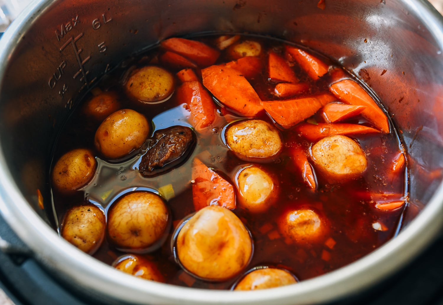 carrots and potatoes added to instant pot with beef