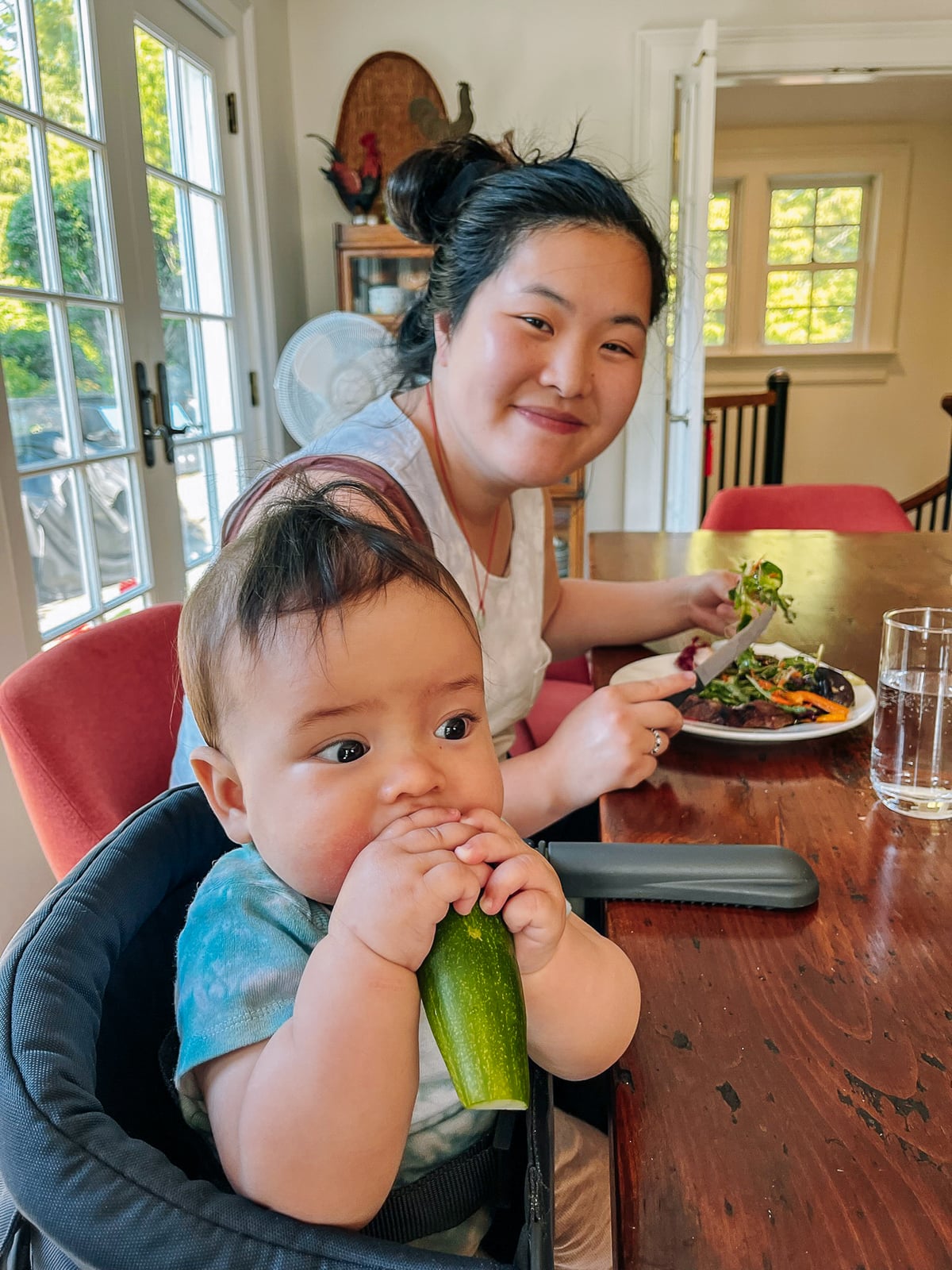 Sarah with Ethan exploring a cucumber halved lengthwise