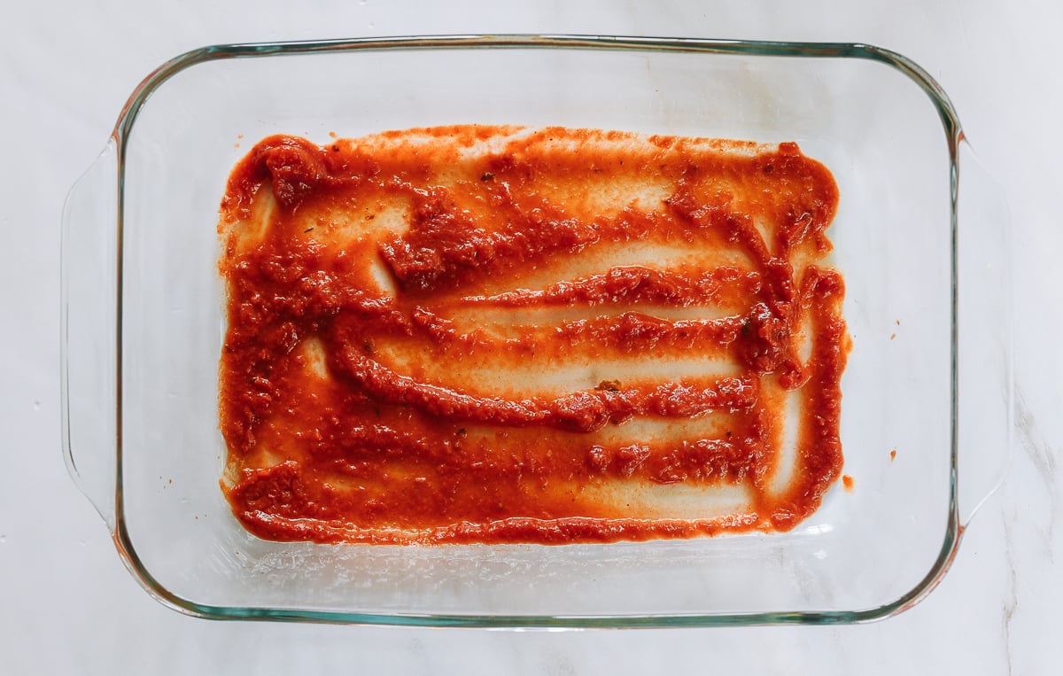marinara sauce at bottom of 9x13 inch baking dish