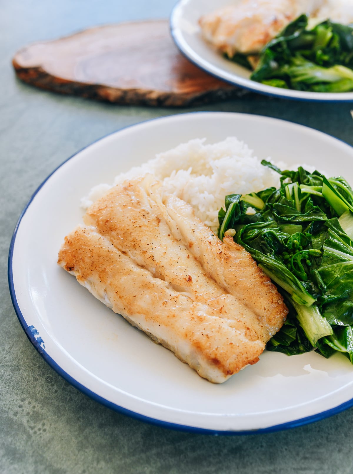Pan-fried cod on a plate with rice and vegetables