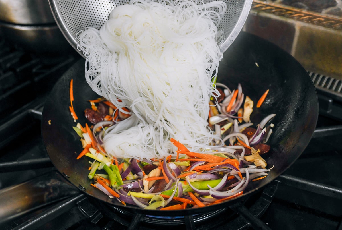 adding rice vermicelli noodles to wok