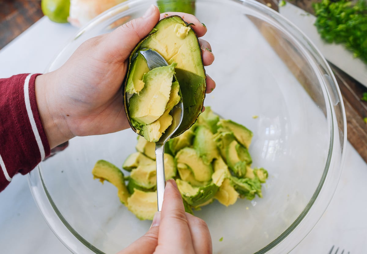 scooping chunks of avocado with a spoon