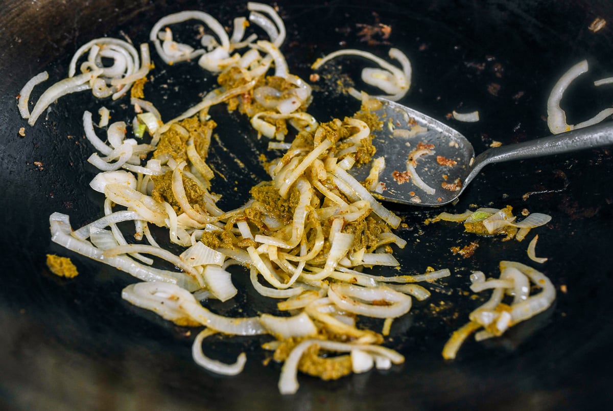 cooking Thai green curry paste and onions