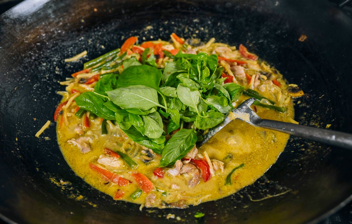 mixing basil into green curry